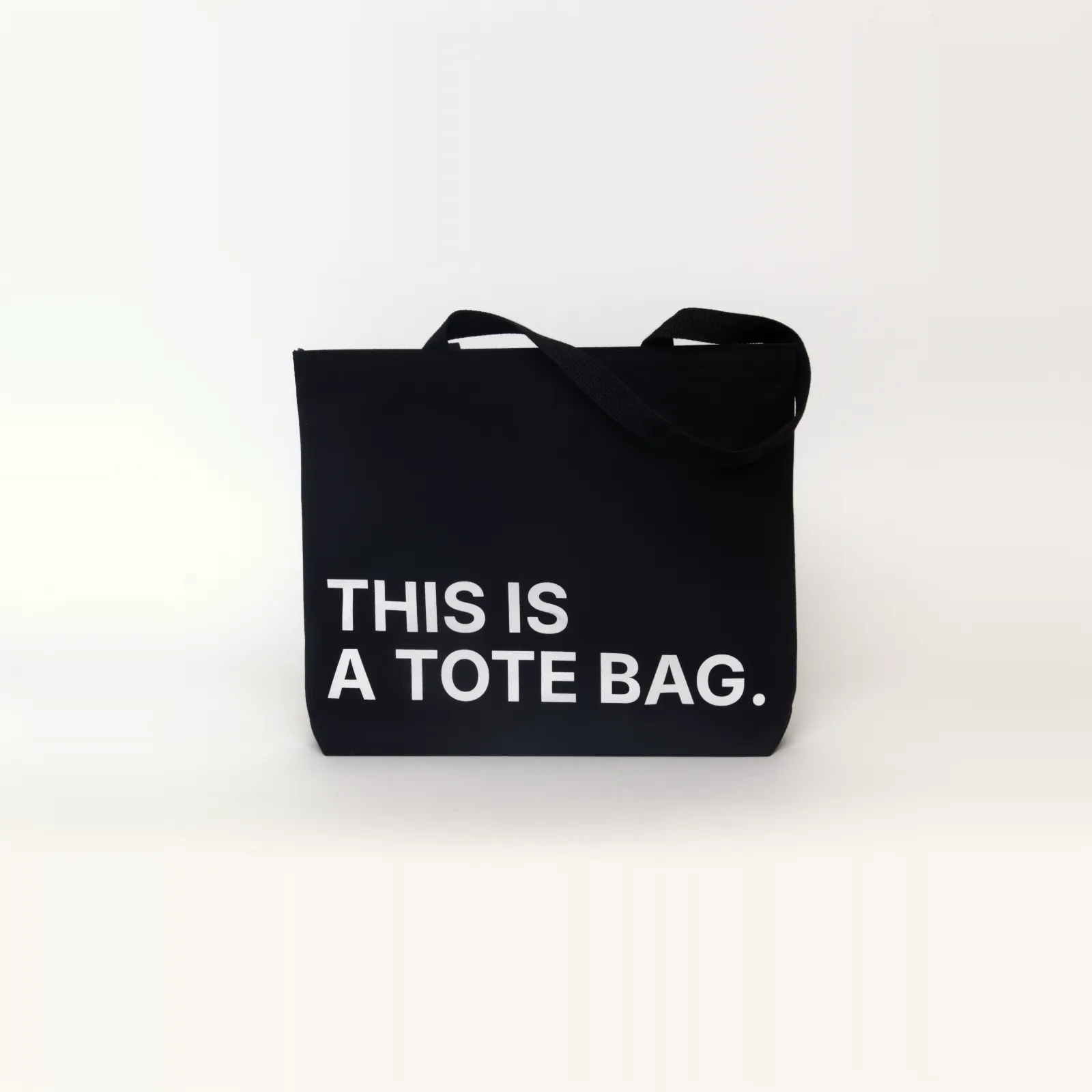 Black tote bag that says THIS IS A TOTE BAG